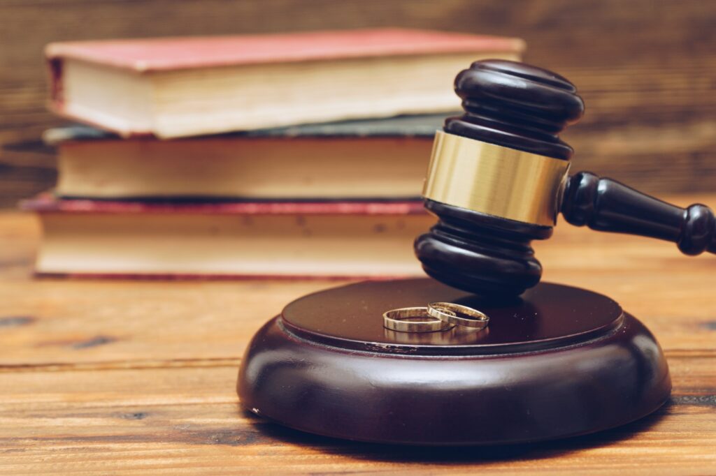 Wooden judge gavel and golden rings, divorce concept
